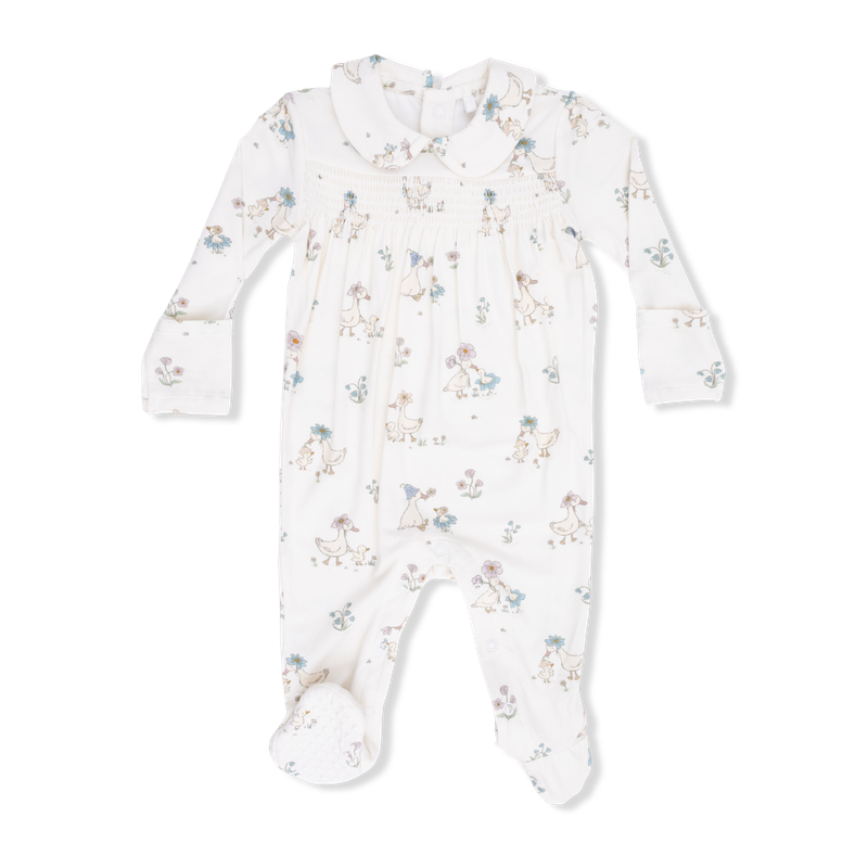 Baby onesie with peter pant collar and smocking with duck and floral pattern on a white background