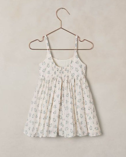 Floral dress on a hanger against a beige wall