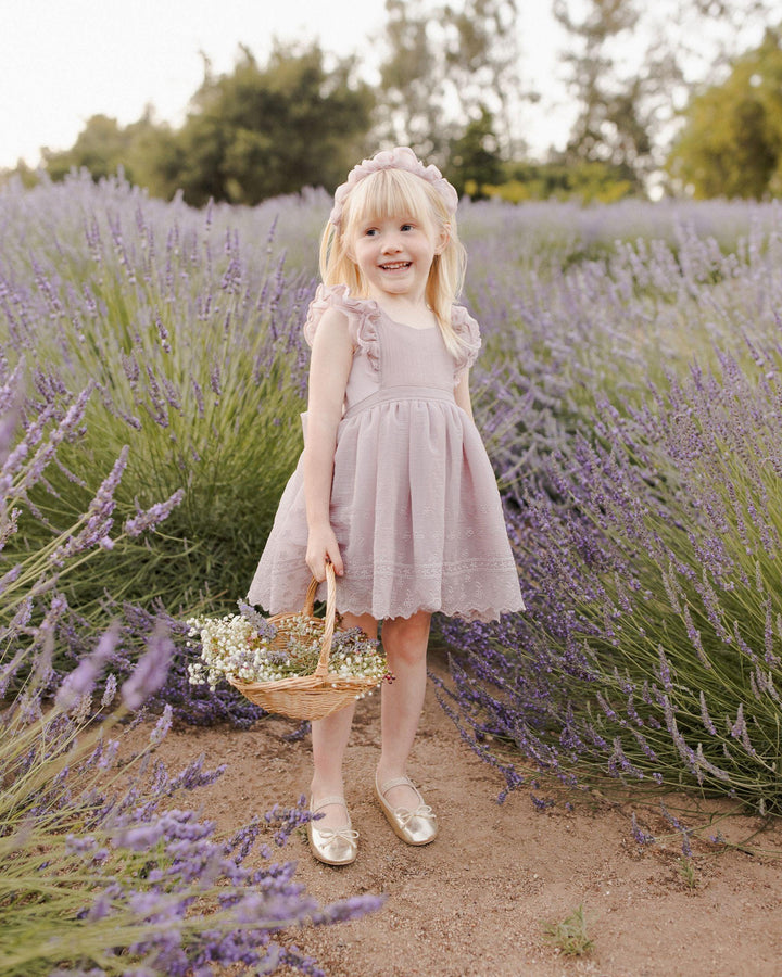 young girl wearing the lavender pinafore in the lavender fields. skirt hits just above the knee. 