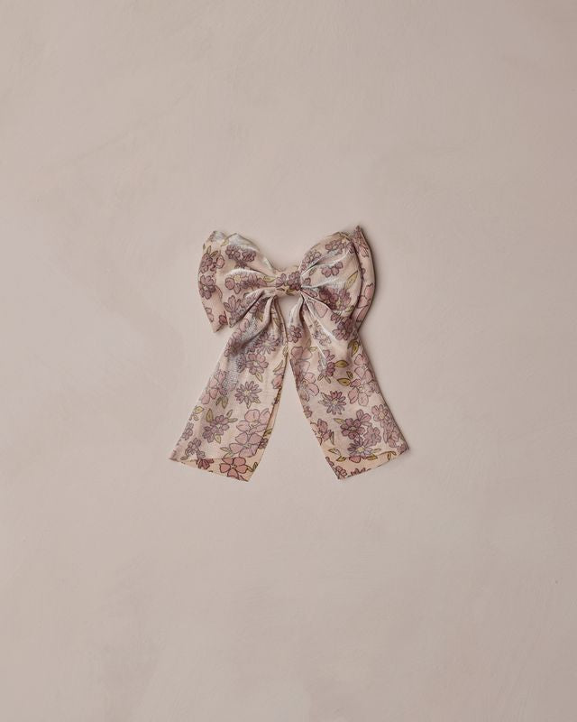 Floral bow with subtle shimmer on a beige background