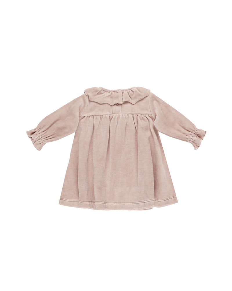 blush pink velour dress with large ruffle at the collar and gathering at the sleeve. two buttons at the top of the back of the dress