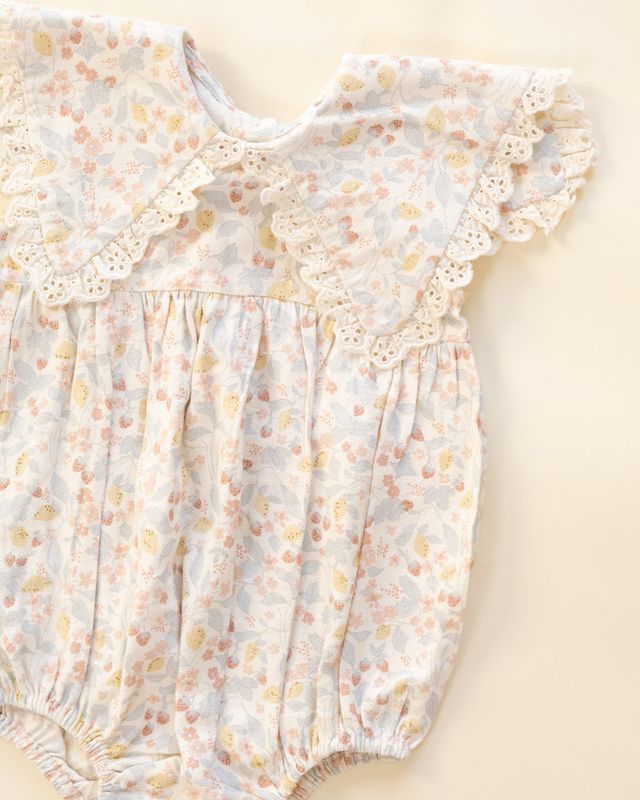 Floral baby romper on a beige background