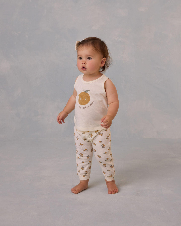 baby modeling the ornages set, tank with smiling orange and pants with oranges all over them. 