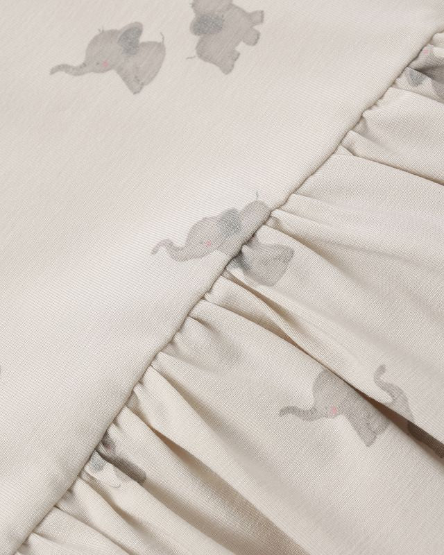 Close-up of a textured fabric with small elephant patterns on a light background