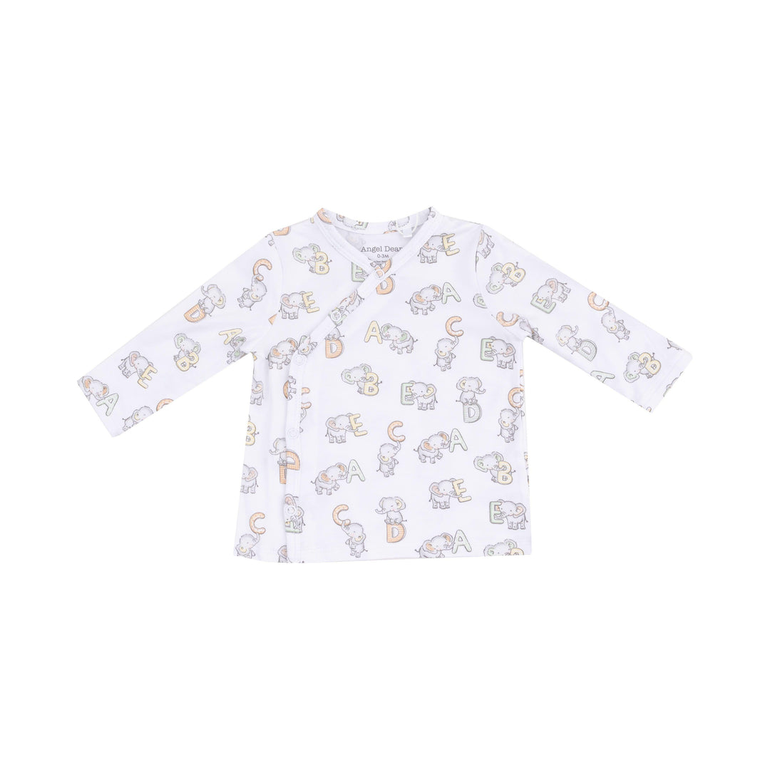 close up of the white top with elephants and SBC print on it. 