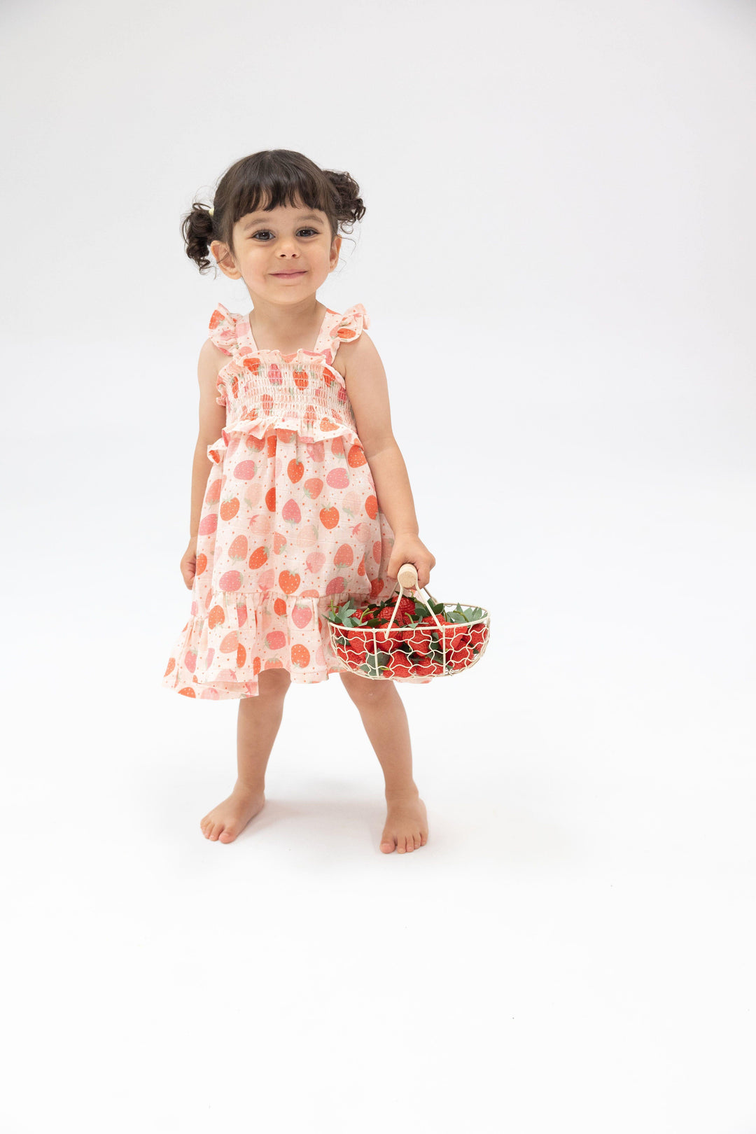 little girl modeling the strawberry smocked sundress, full skirt and smocked top. 