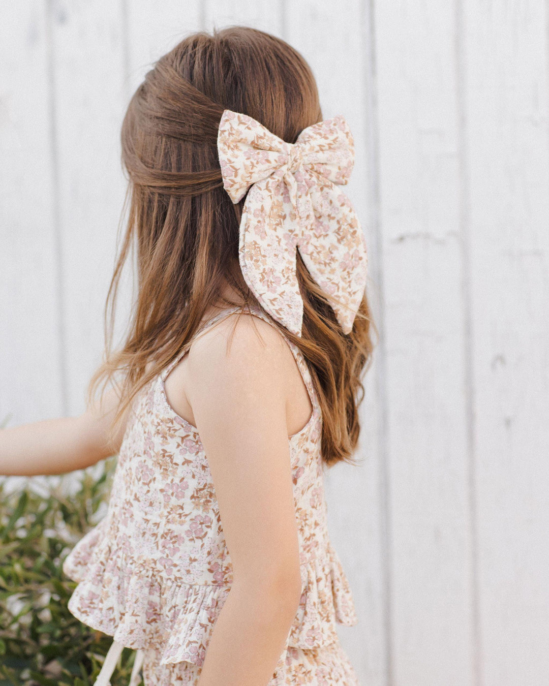 this picture shows a close up of the print on the girl's top and matching bow. warm/natural colored florals. 