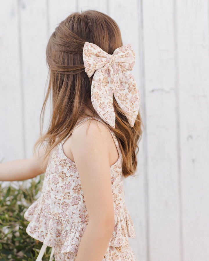 this picture shows a close up of the print on the girl's top and matching bow. warm/natural colored florals. 