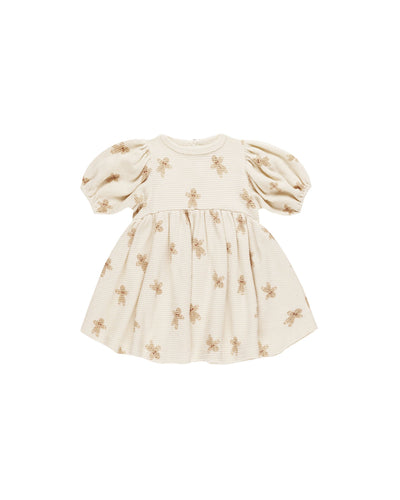 beige waffle baby dress with gingerbread men on it. 