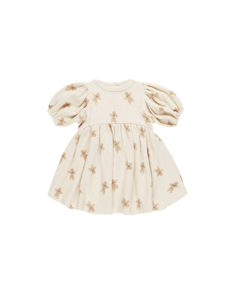 beige waffle baby dress with gingerbread men on it. 