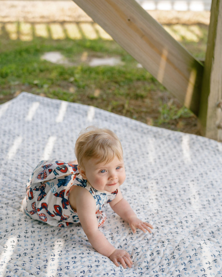 baby crawling in a red, white and bluw bows outfit. 