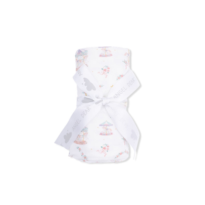 White baby swaddle with colorful carousel on a white background