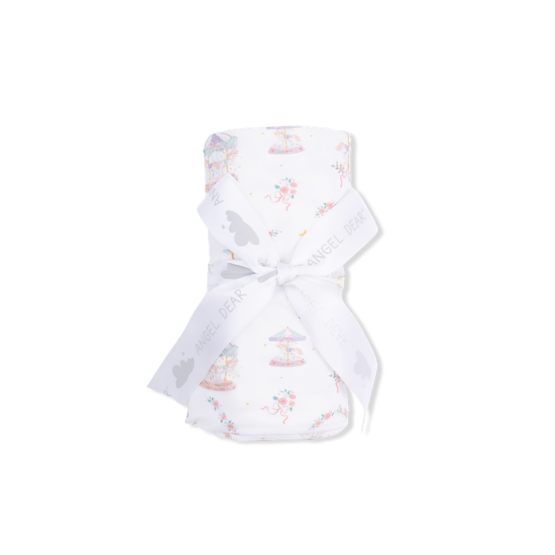 White baby swaddle with colorful carousel on a white background