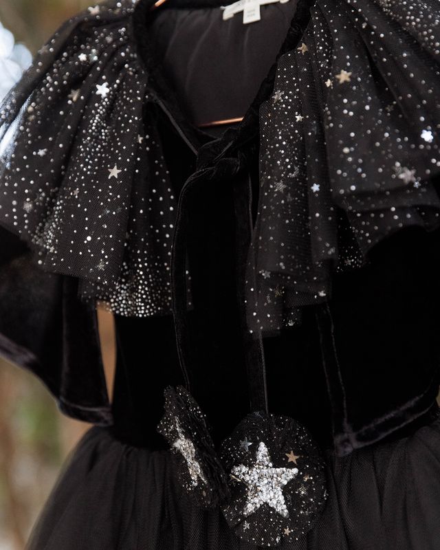 Black shawl with star-shaped sequins on a blurred background