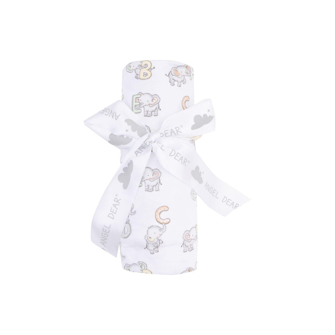 baby swaddle rolled up and tied with a ribbon elephant printed with ABC's on it. 