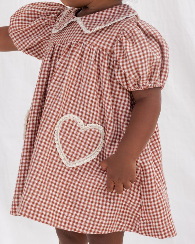 Red and white checkered dress with a heart design on a plain background