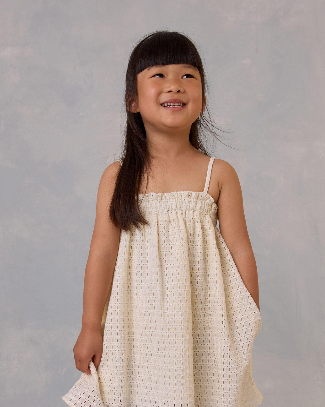 little girl modeling the ivory eyelet dress and spaghetti strap