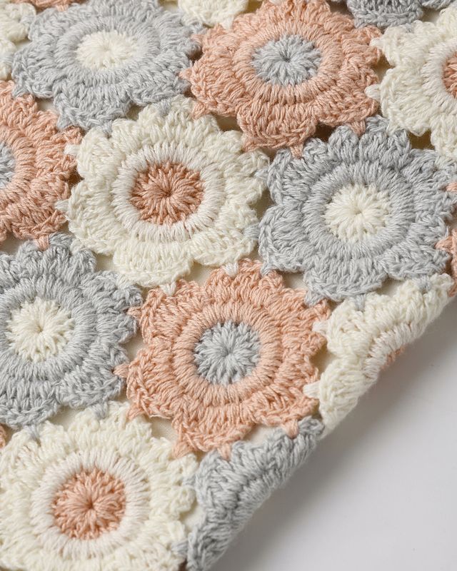 Close-up of crocheted flowers in pastel colors on a white background