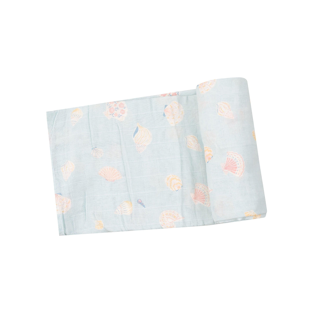 light blue swaddle with beige/peach shells printed on it. 