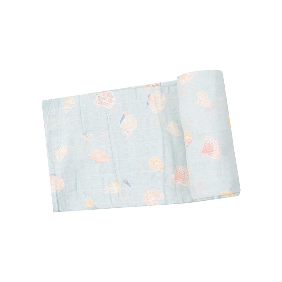 light blue swaddle with beige/peach shells printed on it. 