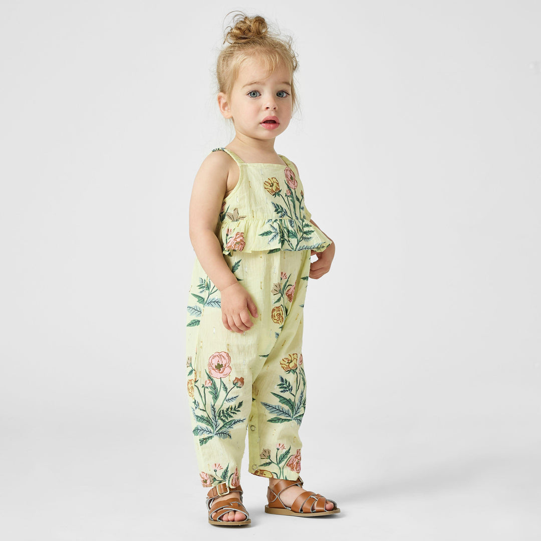 this shows the baby wearing the jumpsuit from the front with a peplum waist that hits at the waist. nice relaxed fit throughout