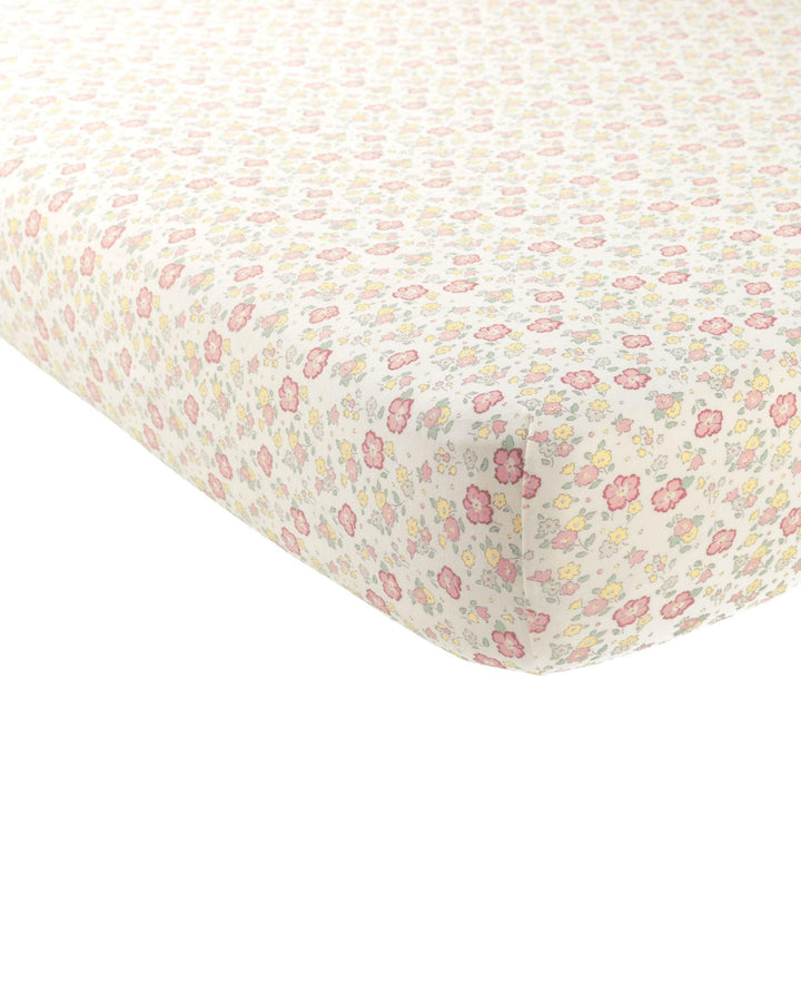 crib sheet in floral print: pink, yellow and sage green flowers. 