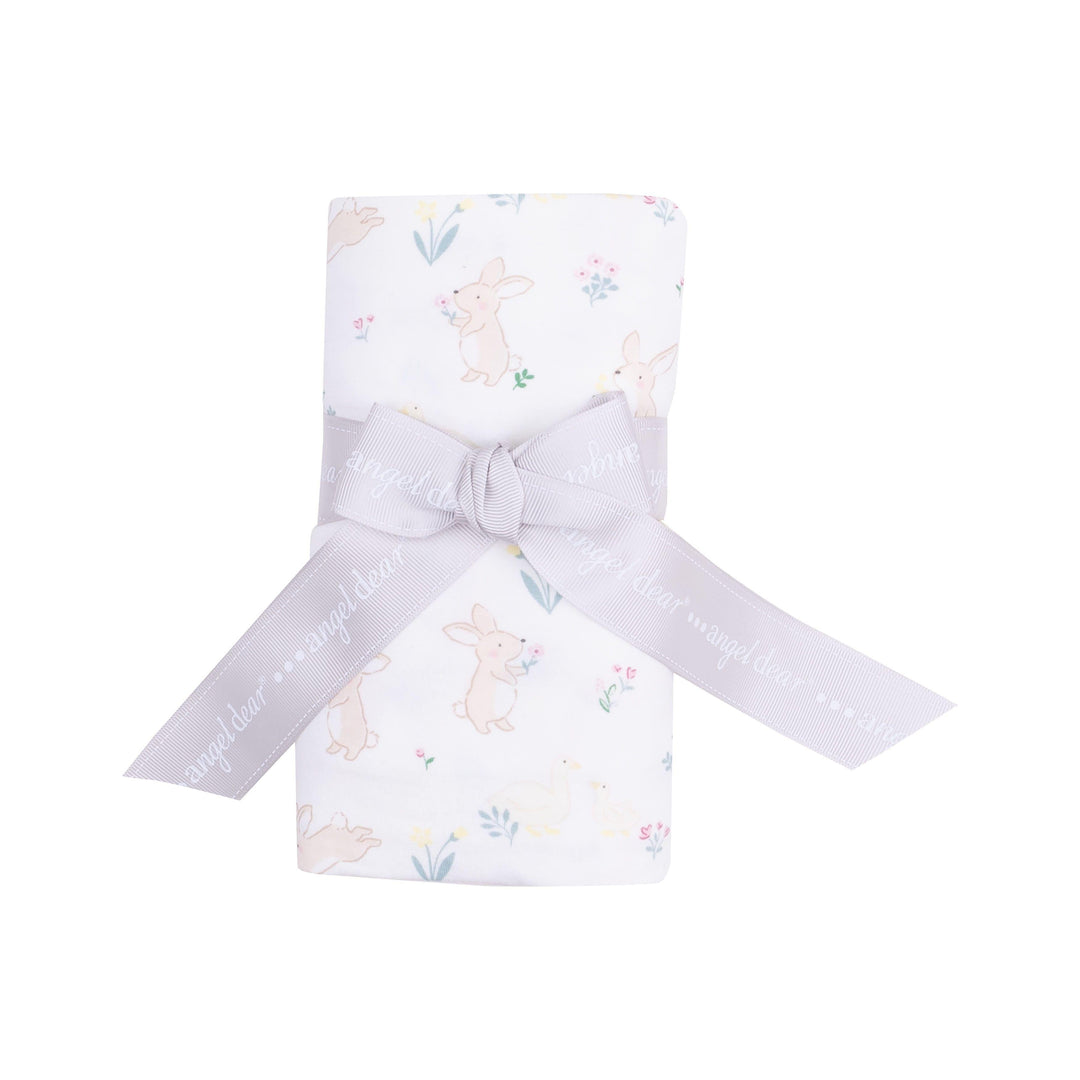 this picture shows the swaddle rolled up with white background and has tiny bunnies and chicks and tiny flowers all over. 