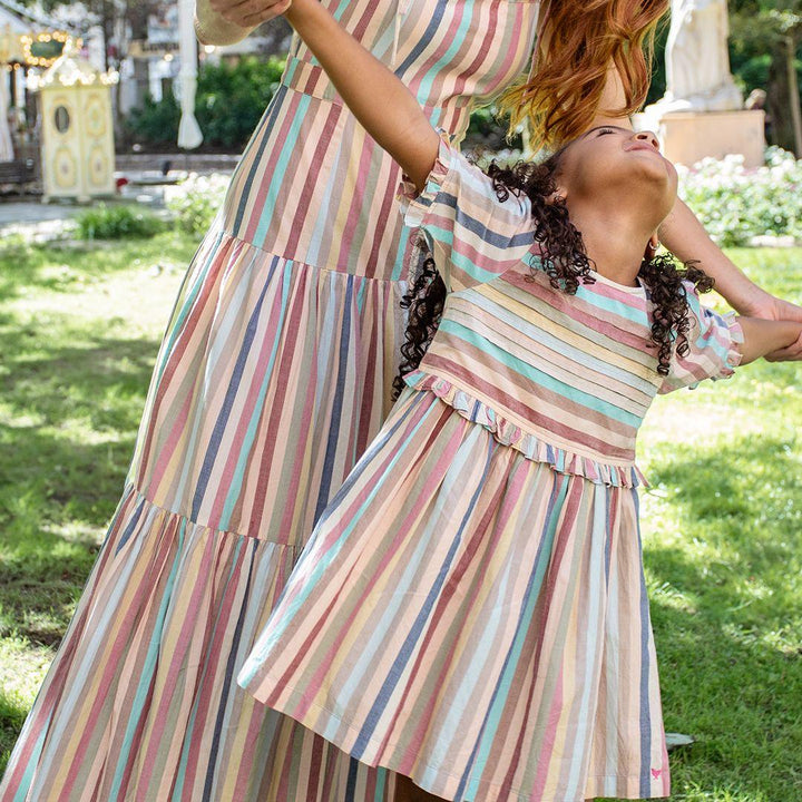 young girl lovingly staring up at the woman who is wearing a matching dress to the young girl
