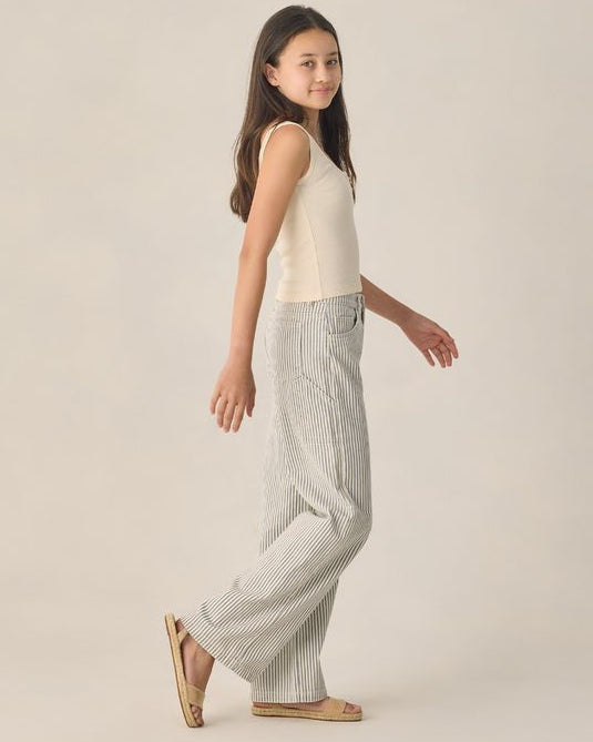 Young Woman wearing a sleeveless top and checkered pants on a beige background