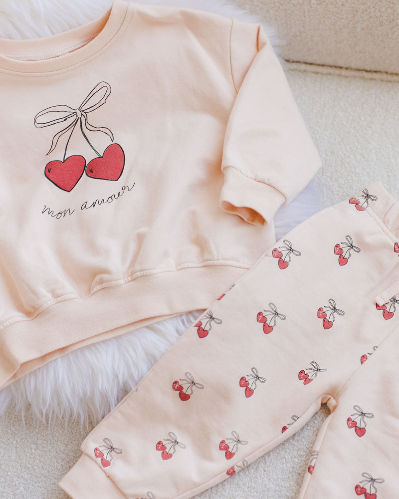 light pink/beige sweatset with cherries all over the pants and a bigger picture of the cherries on the sweatshirt. 