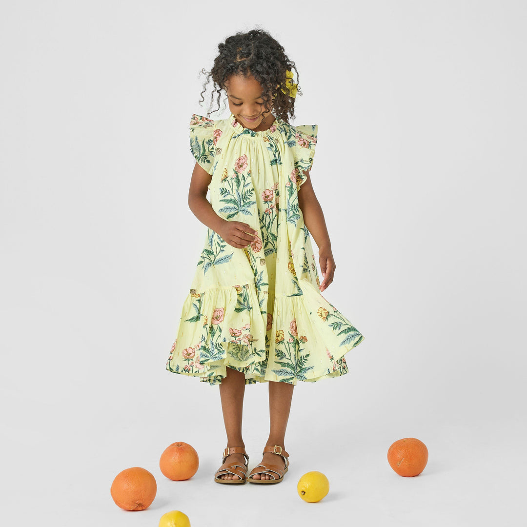 little girl wearing the yellow dress. this picture shows the movement in the dress and the ruffle at the sleeve. 