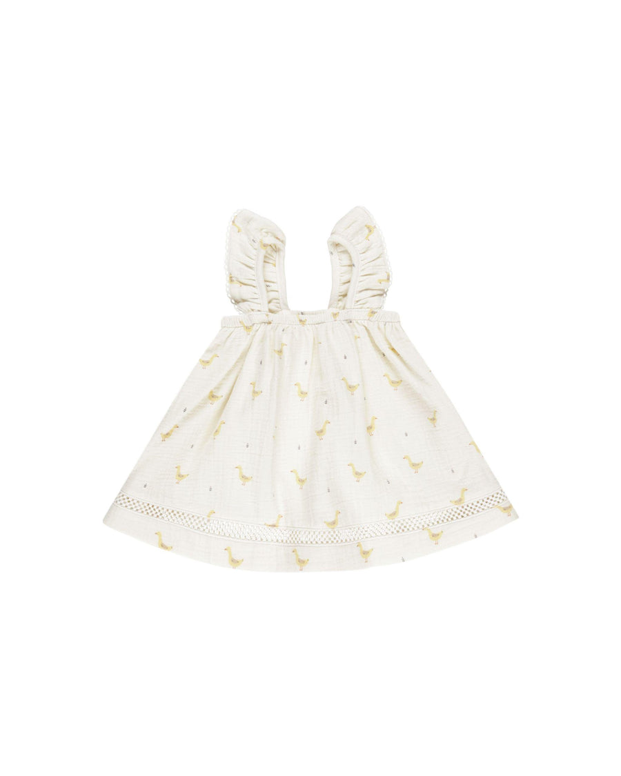 beige dress with yellow geese printed on it. sleeveless ruffles for sleeves. 
