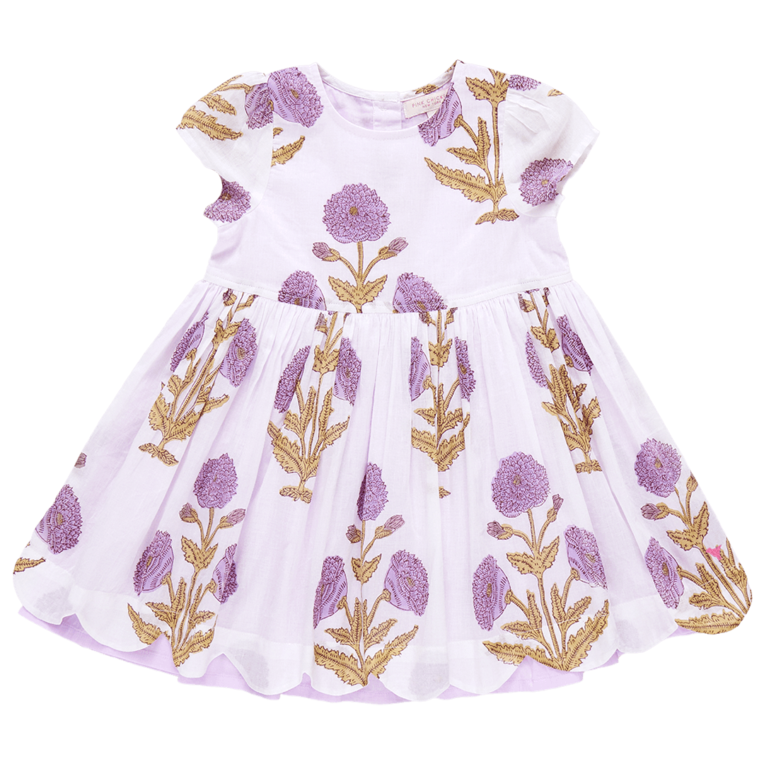 ivory dress with lavender marisol flowers printed on it. flowers are large with a scallop edge at the bottom of the skirt. the inlay of the skirt is lavender