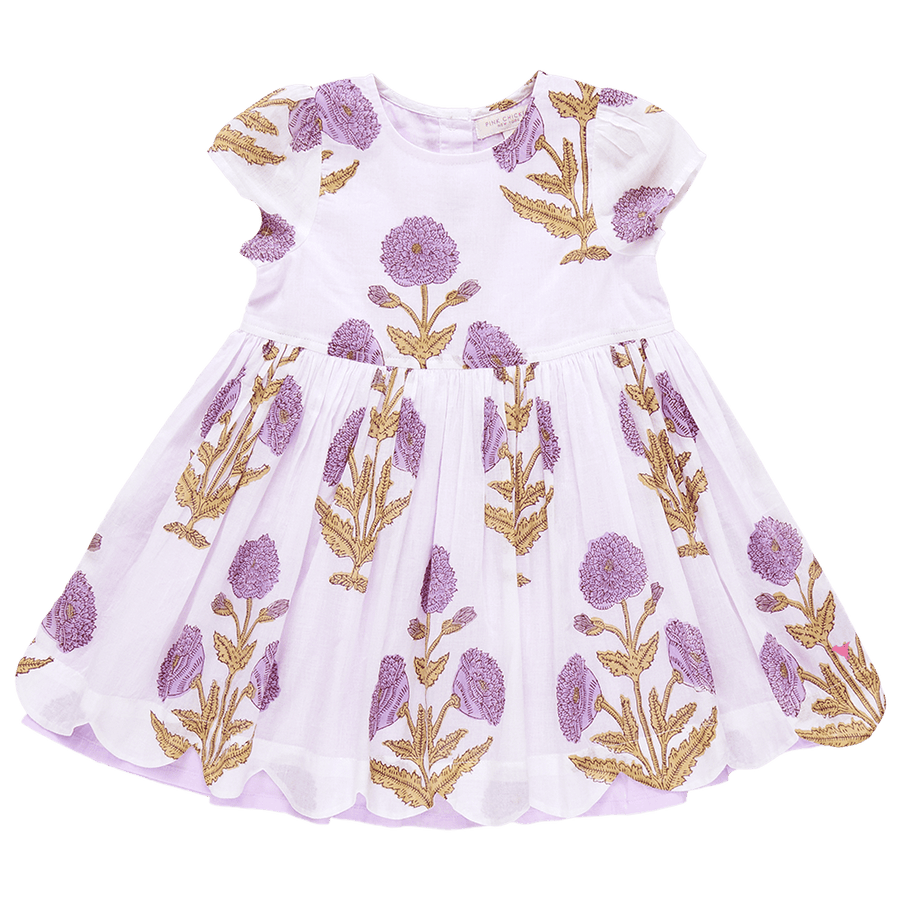 ivory dress with lavender marisol flowers printed on it. flowers are large with a scallop edge at the bottom of the skirt. the inlay of the skirt is lavender