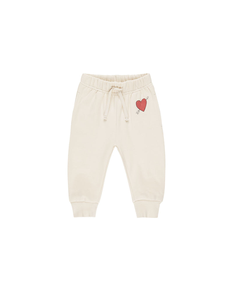 beige sweatpants with burgindy heart on the top left corner