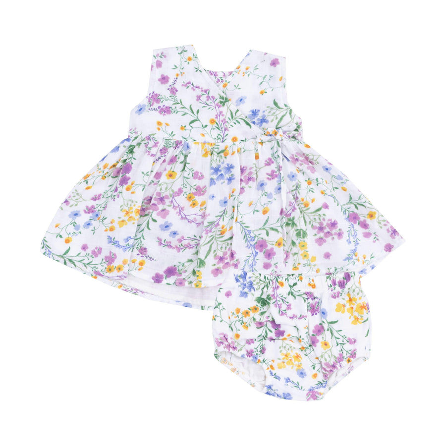 baby girl dress in a kimono style dress. white base color with delicate florals in purple, blue and yellow flowers. 