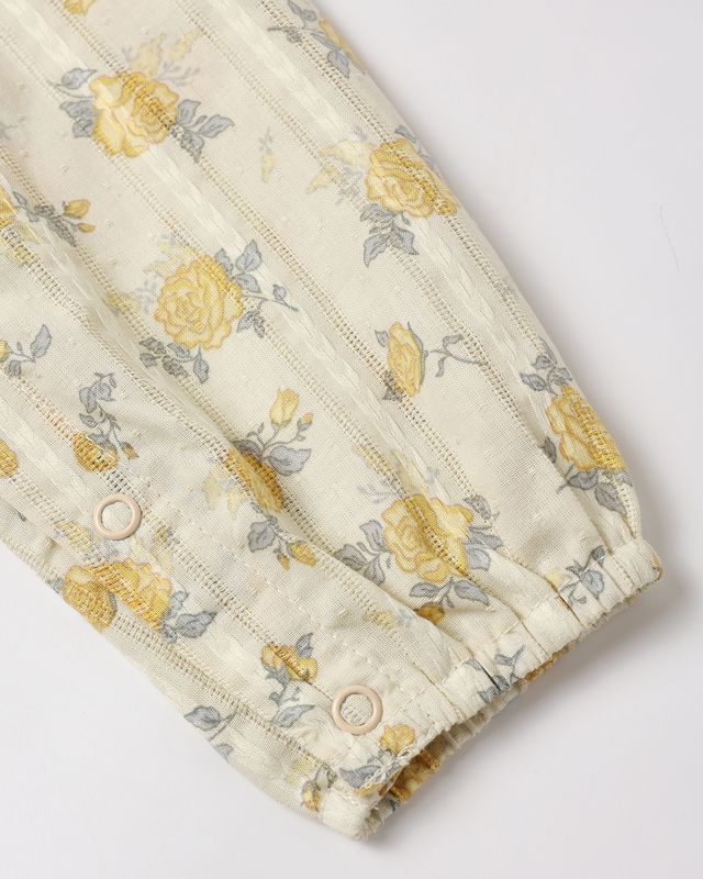 Floral patterned fabric with yellow and gray flowers on a white background