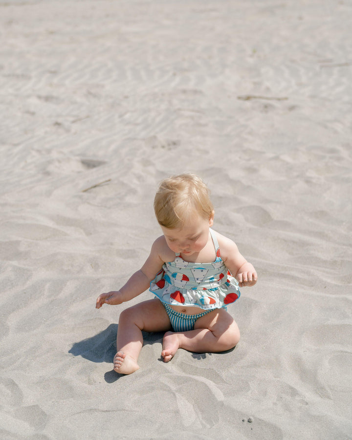 baby wearing a 2 piece bathing suit with snow cone top. 
