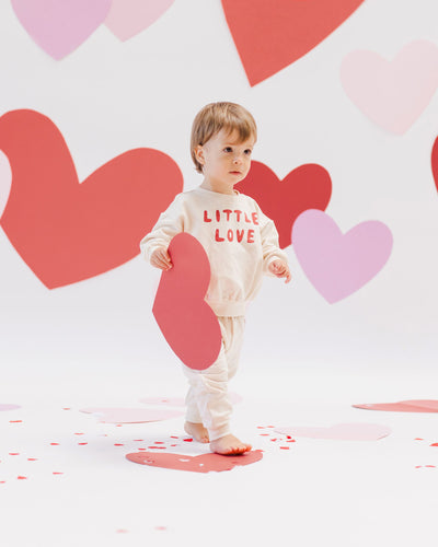 toddler boy modeling the sweatset with the words "Little Love" across the center of the sweatshirt