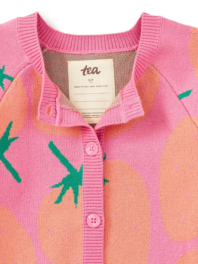 Pink cardigan with strawberry pattern and 'tea' brand label