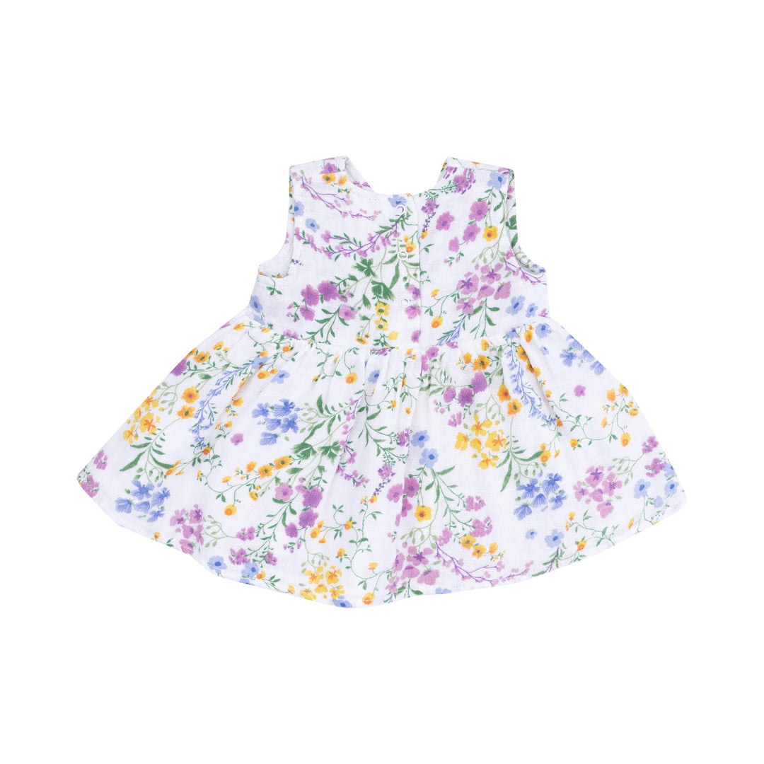 back of baby girl dress in white with purple, yellow and blue tiny florals all over it. 3 duttons at the back of the dress. 