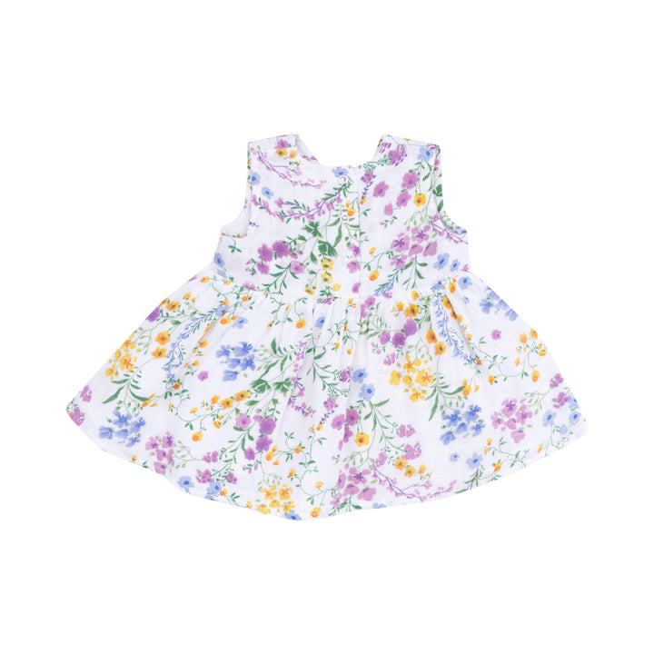 back of baby girl dress in white with purple, yellow and blue tiny florals all over it. 3 duttons at the back of the dress. 