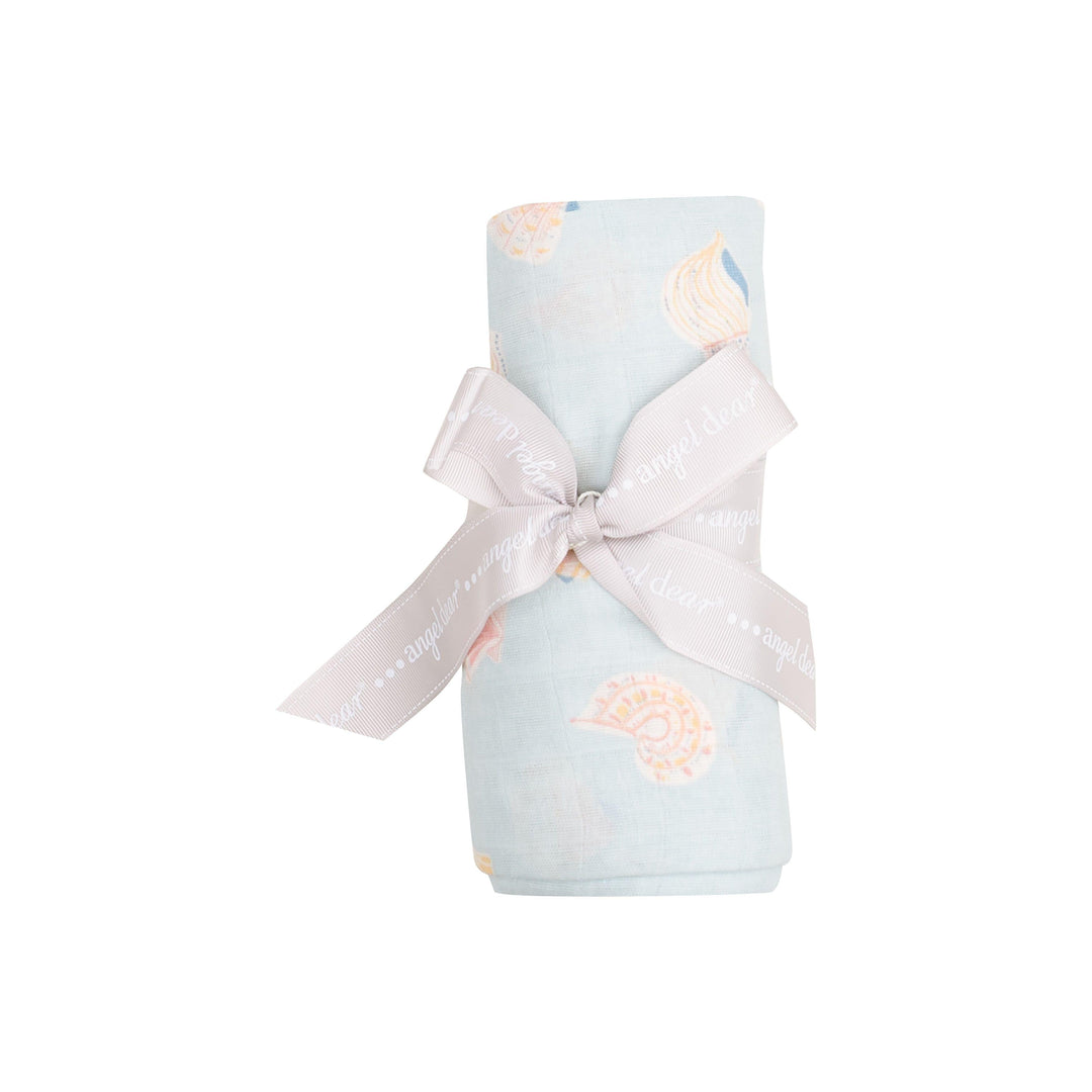 swaddle tied and rolled with a ribbon, light blue with shells in a peach/beige color. this is how it looks when the swaddle is sold to a customer. 