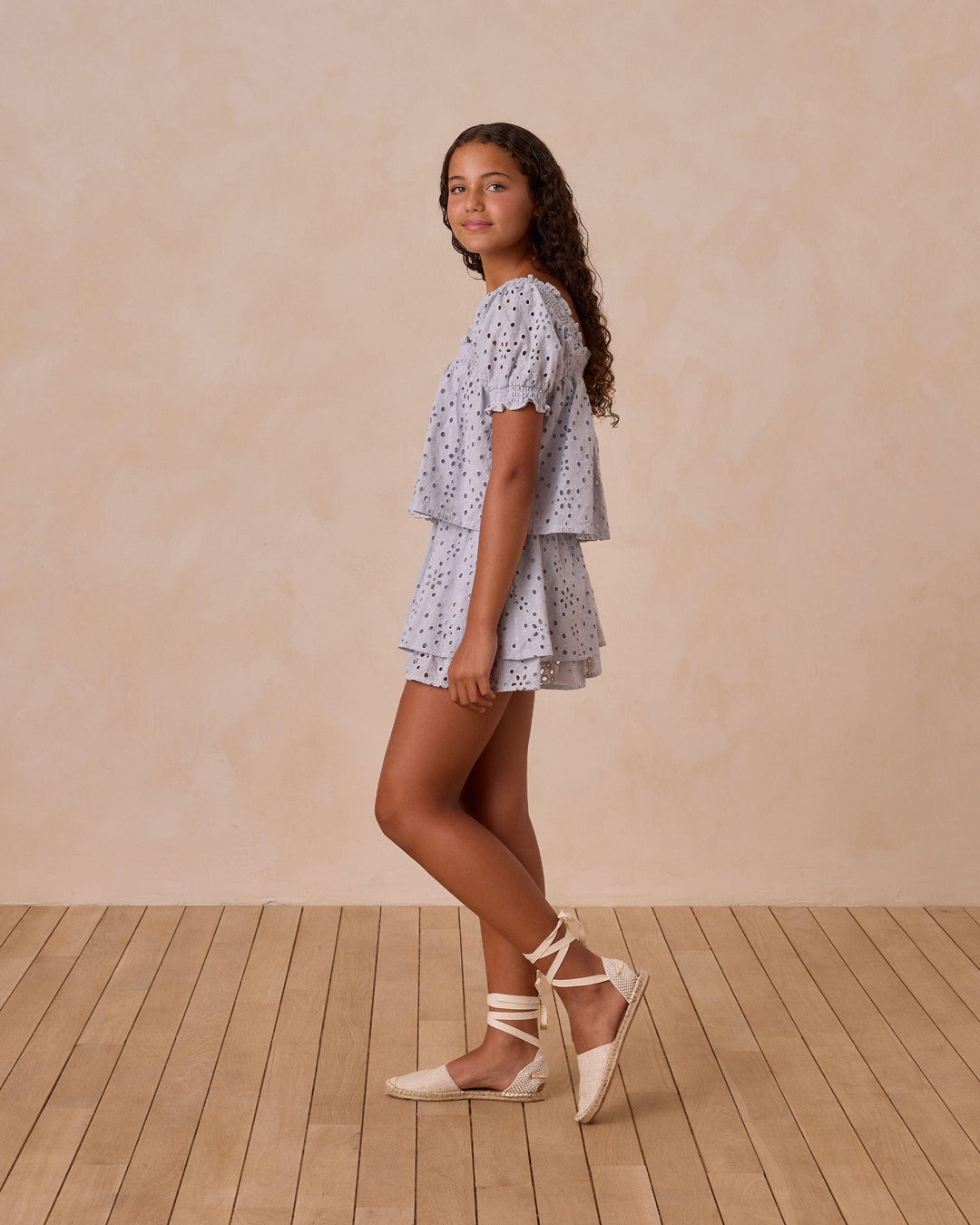 sideview of the blue eyelet top and skirt. puff sleeve and two tiers of the eyelet skirt 