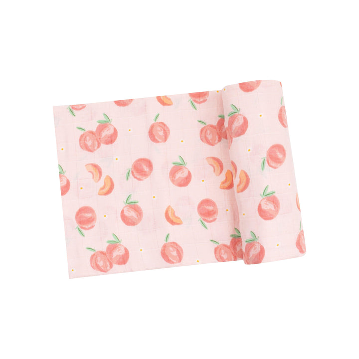 light pink swaddle with peaches on it whole, and slies of peach as well. 
