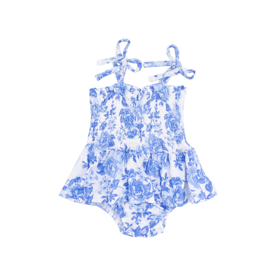 blue roses on a white smocked bubble with peplum skirt. ties at the shoulder and snaps at the bottom for easy diaper changes