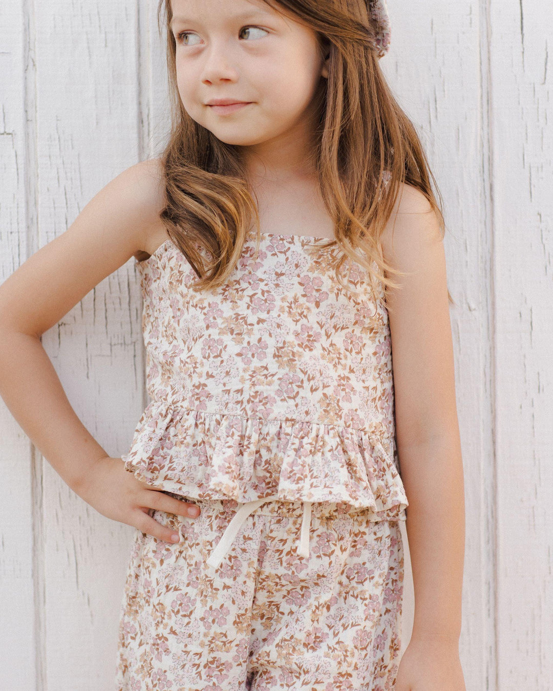 little girl modeling the wildflower pant set, sleeveless with ruffle at the bottom of the top and matching pants with drawstring. 