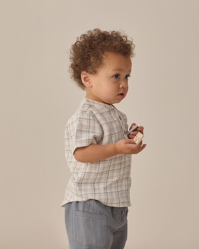 baby boy wearing the blue plaid shirt and blue cotton shorts. 