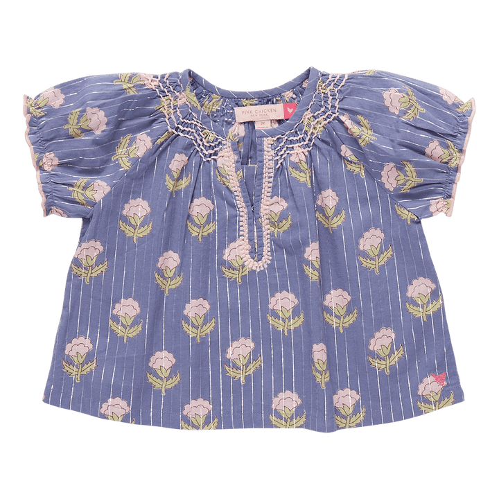 girls top with a notch in the top, blue base color with silver lurex running through it and light pink flowers and stitching on the edges. 