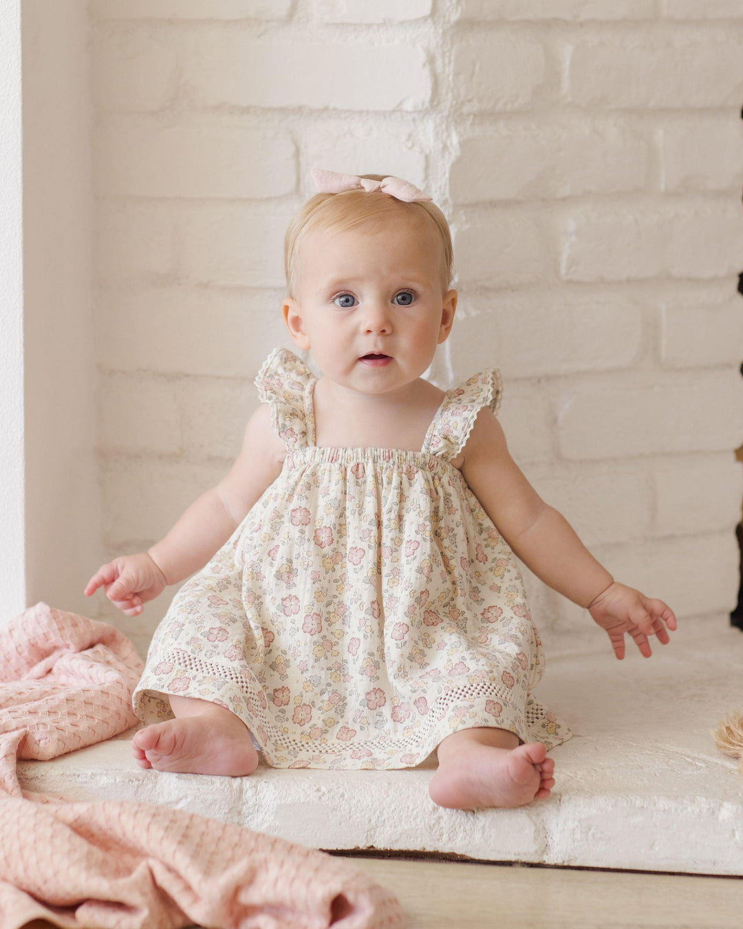 this picture shows a baby wearing the dress and how the sleeves look on the baby and where the dress hits the baby as she is sitting. the dress his mid leg while sitting and when standing would hit at the knee. 